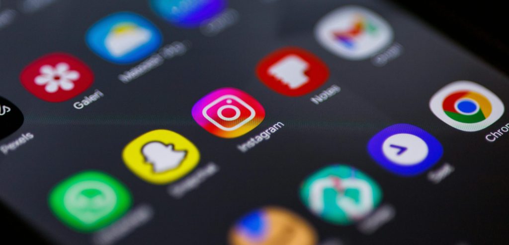 Close-up view of smartphone home screen featuring popular apps like Instagram, Snapchat, and Chrome.