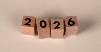 Wooden cubes forming the year 2026 on a neutral background.