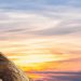 Climber conquers rock face at sunset, embracing the thrill and challenge.