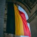 Vibrant Belgian flag under iconic archway in Brussels, symbolizing national pride.